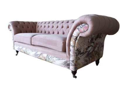 A vibrant three-seater Chesterfield sofa with a delicate pink floral pattern